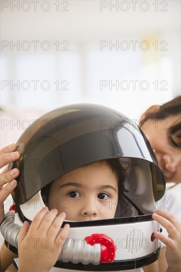 Hispanic mother and daughter playing dress up