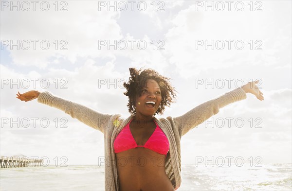 African American woman cheering on beach