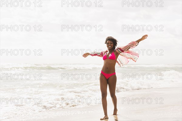 African American woman walking on beach