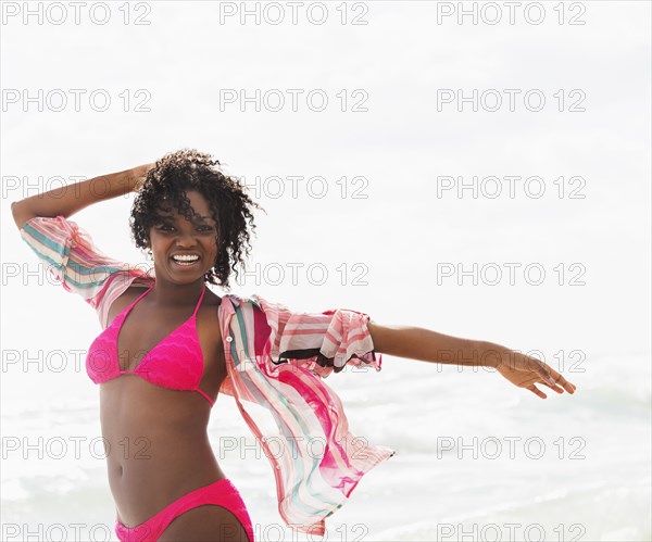 African American woman walking on beach