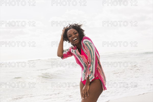 African American woman laughing on beach