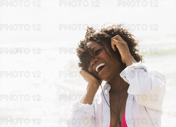 African American woman listening to headphones outdoors