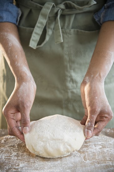 Mixed race woman kneading dough