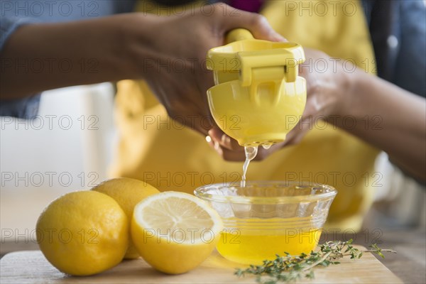 Mixed race woman squeezing lemons