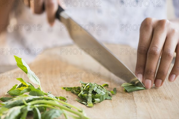 Mixed race woman chopping herbs