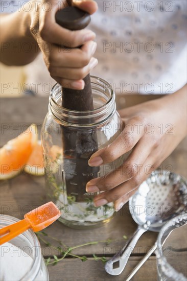 Mixed race woman muddling cocktail