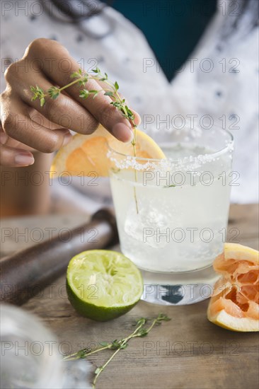 Mixed race woman making cocktail