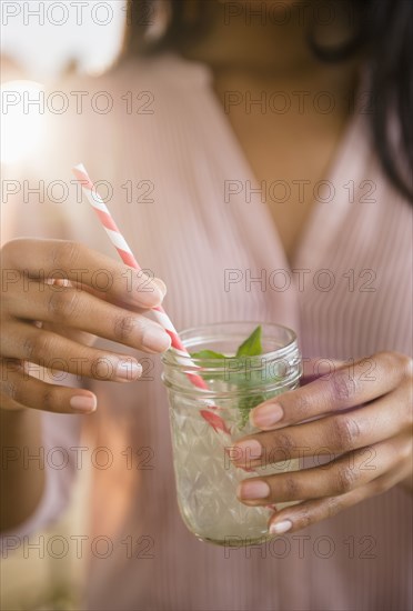 Mixed race woman drinking cocktail