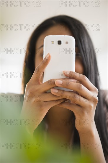 Mixed race woman using cell phone