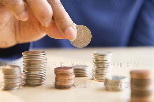 Mixed race woman stacking coins