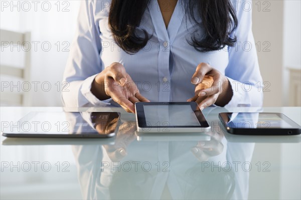 Mixed race businesswoman using digital tablets