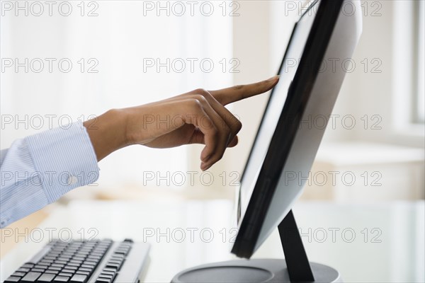 Mixed race businesswoman working on touch screen computer