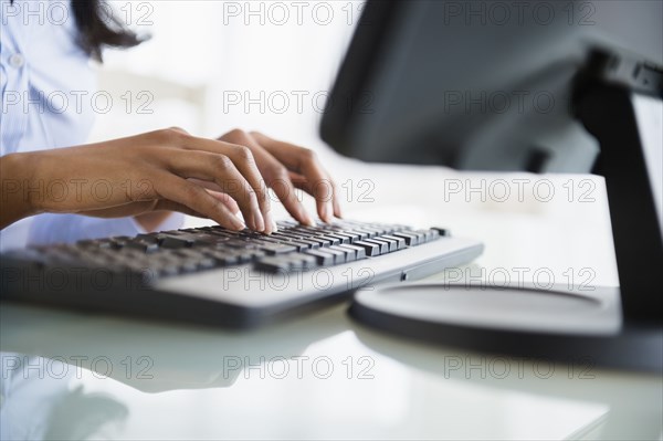 Mixed race businesswoman working on computer