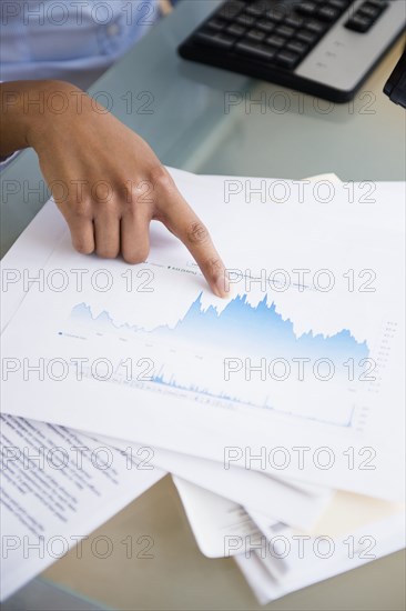 Mixed race businesswoman reading graphs