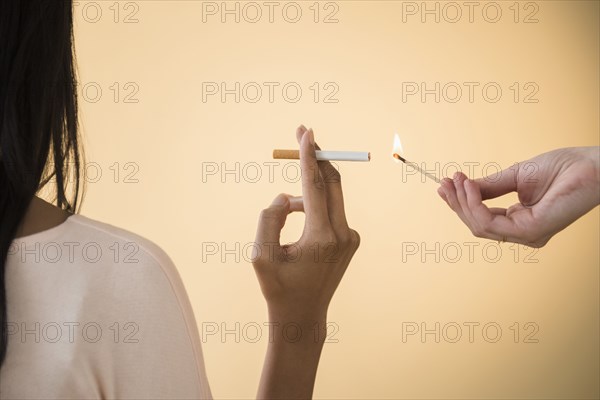 Man lighting woman's cigarette