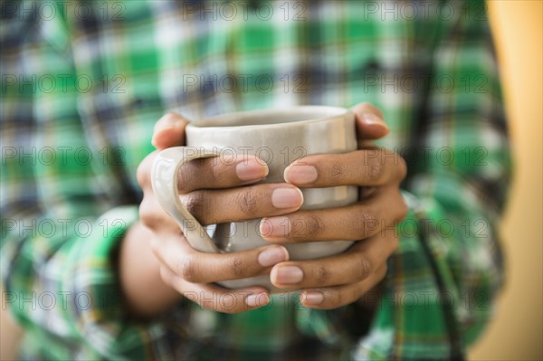 Mixed race woman holding cup of coffee