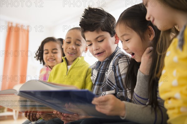 Children reading together in living room