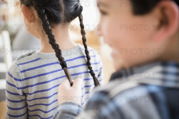 Boy pulling girl's pigtails