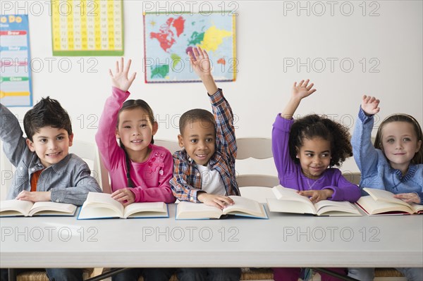 Students raising hands in classroom