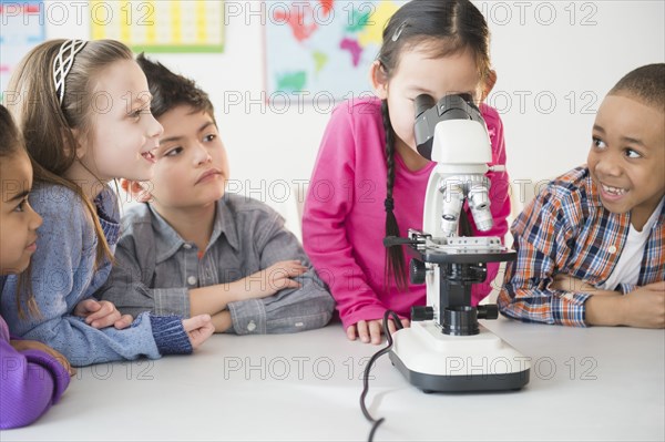 Students using microscope in classroom