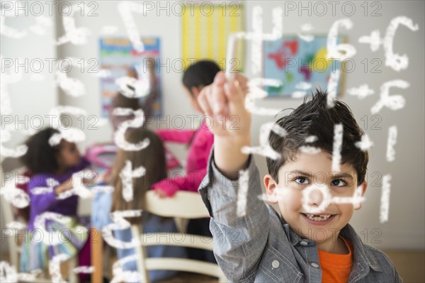 Boy doing math problems in classroom