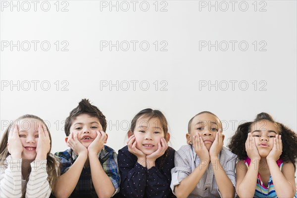 Children resting chins in hands