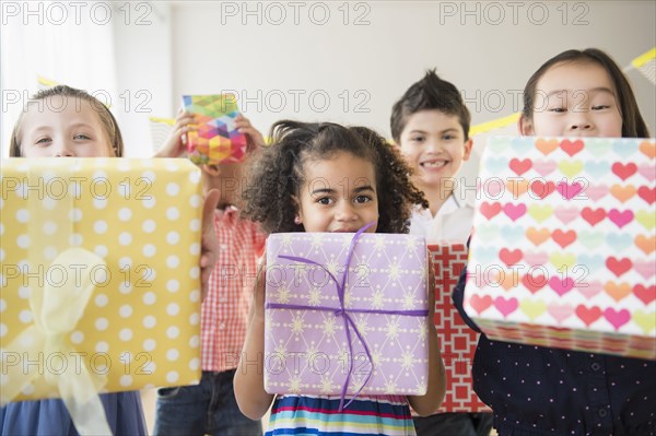 Children holding birthday presents at party