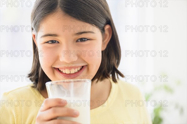 Hispanic girl drinking glass of milk