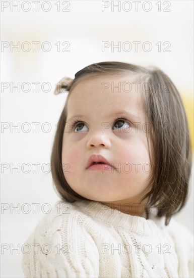 Hispanic toddler with Down syndrome looking up