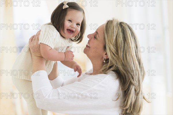 Hispanic mother playing with daughter in living room