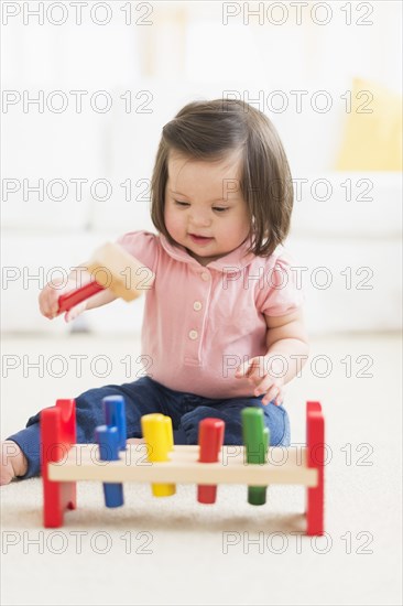 Hispanic toddler with Down syndrome playing