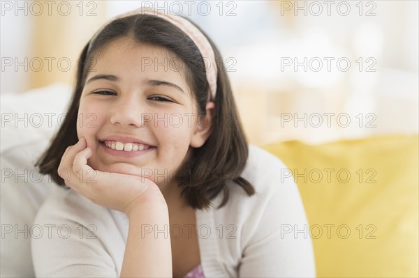 Hispanic girl smiling on sofa