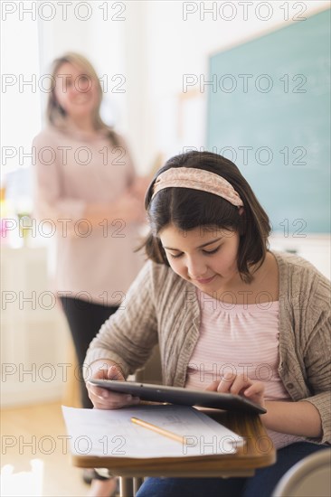 Hispanic girl using digital tablet in classroom