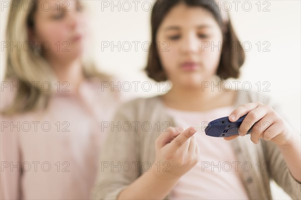 Hispanic girl testing her blood sugar