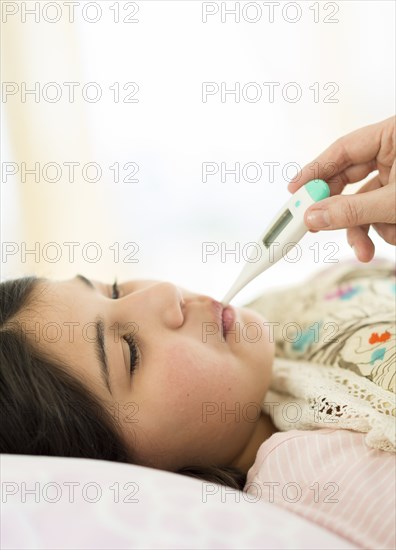 Hispanic girl taking her temperature