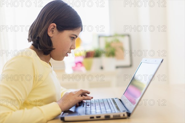 Hispanic girl using laptop at desk