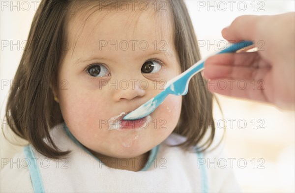 Hispanic mother feeding toddler