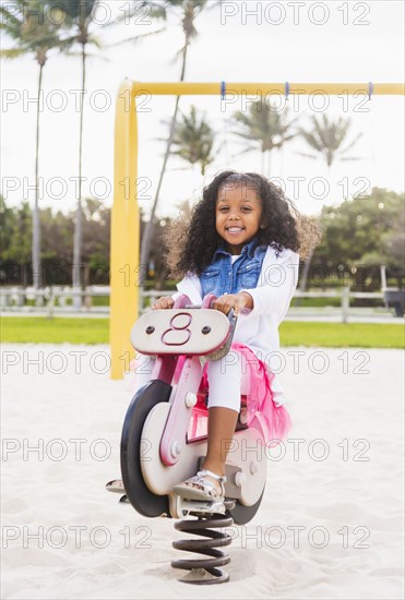 Mixed race girl playing on playground