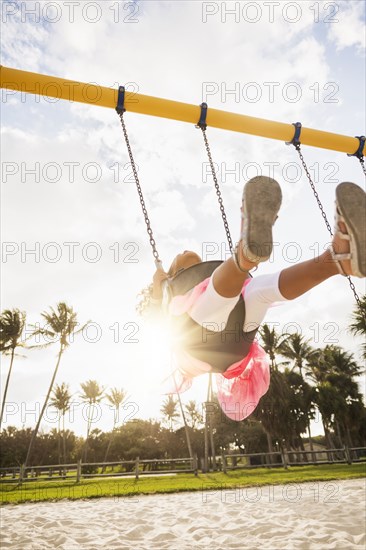 Mixed race girl playing on playground