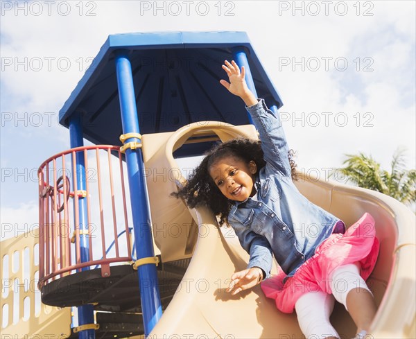 Mixed race girl playing on playground