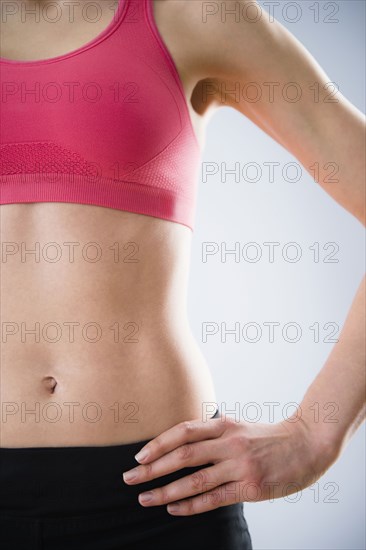 Caucasian woman with bare stomach wearing sports clothing