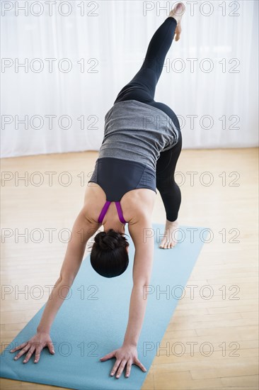 Caucasian woman stretching on yoga mat