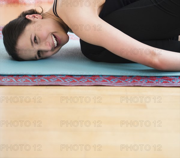 Caucasian woman smiling on yoga mat