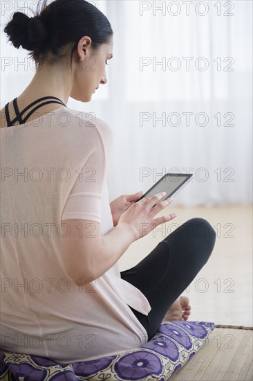 Caucasian woman using tablet computer in living room