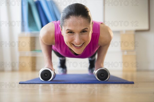 Caucasian woman doing push ups on yoga mat