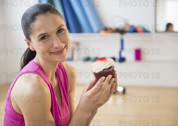 Caucasian woman holding cupcake