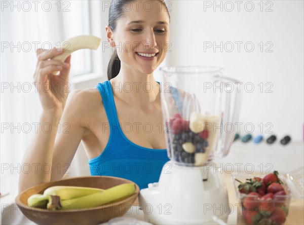 Caucasian woman blending fruit smoothie
