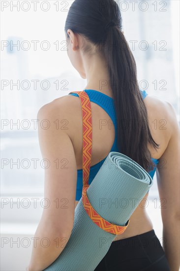 Caucasian woman carrying yoga mat