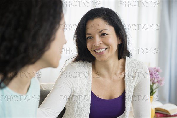 Mother and daughter talking in living room
