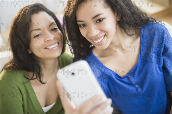 Mother and daughter taking picture with cell phone